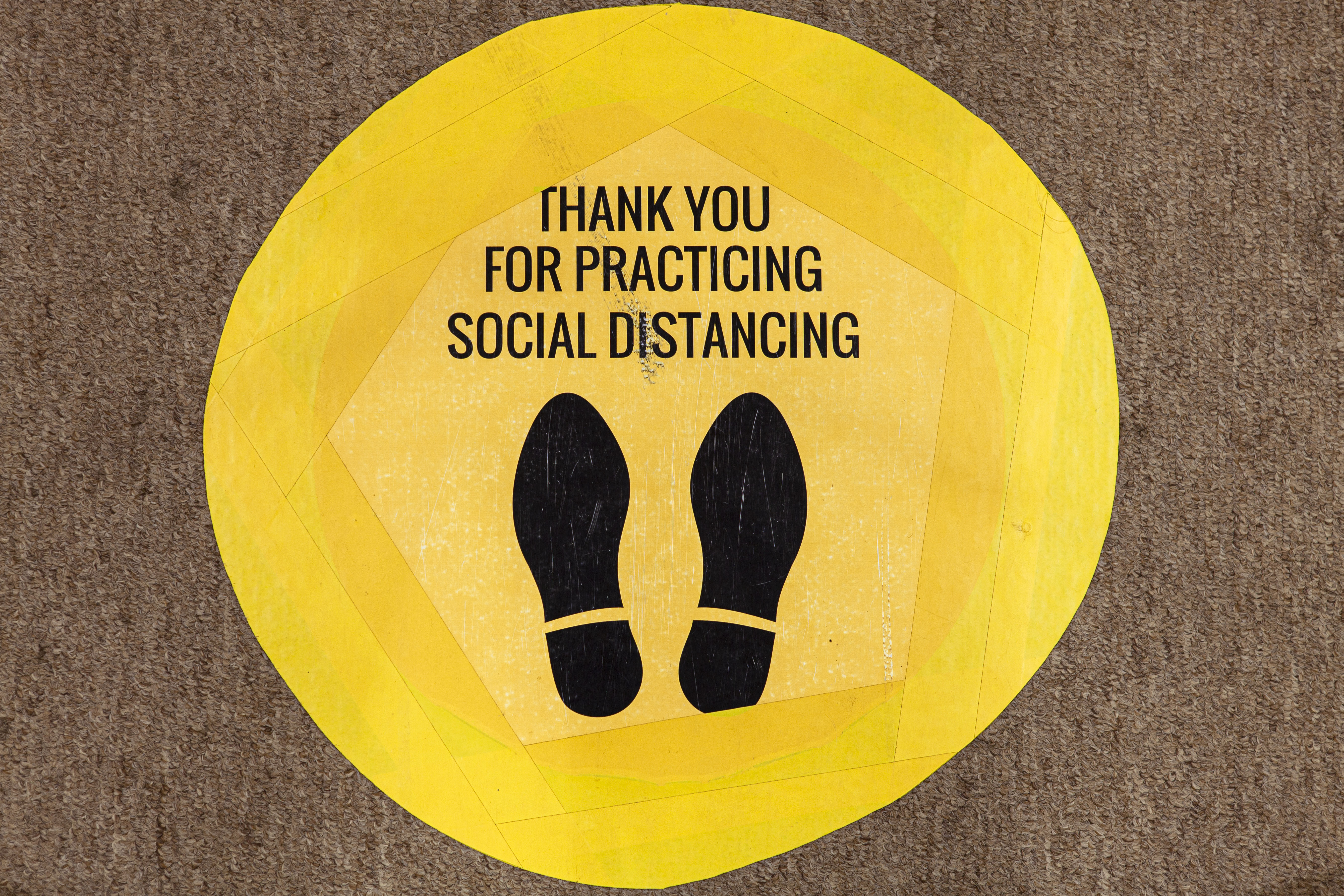 yellow social distance sticker on floor